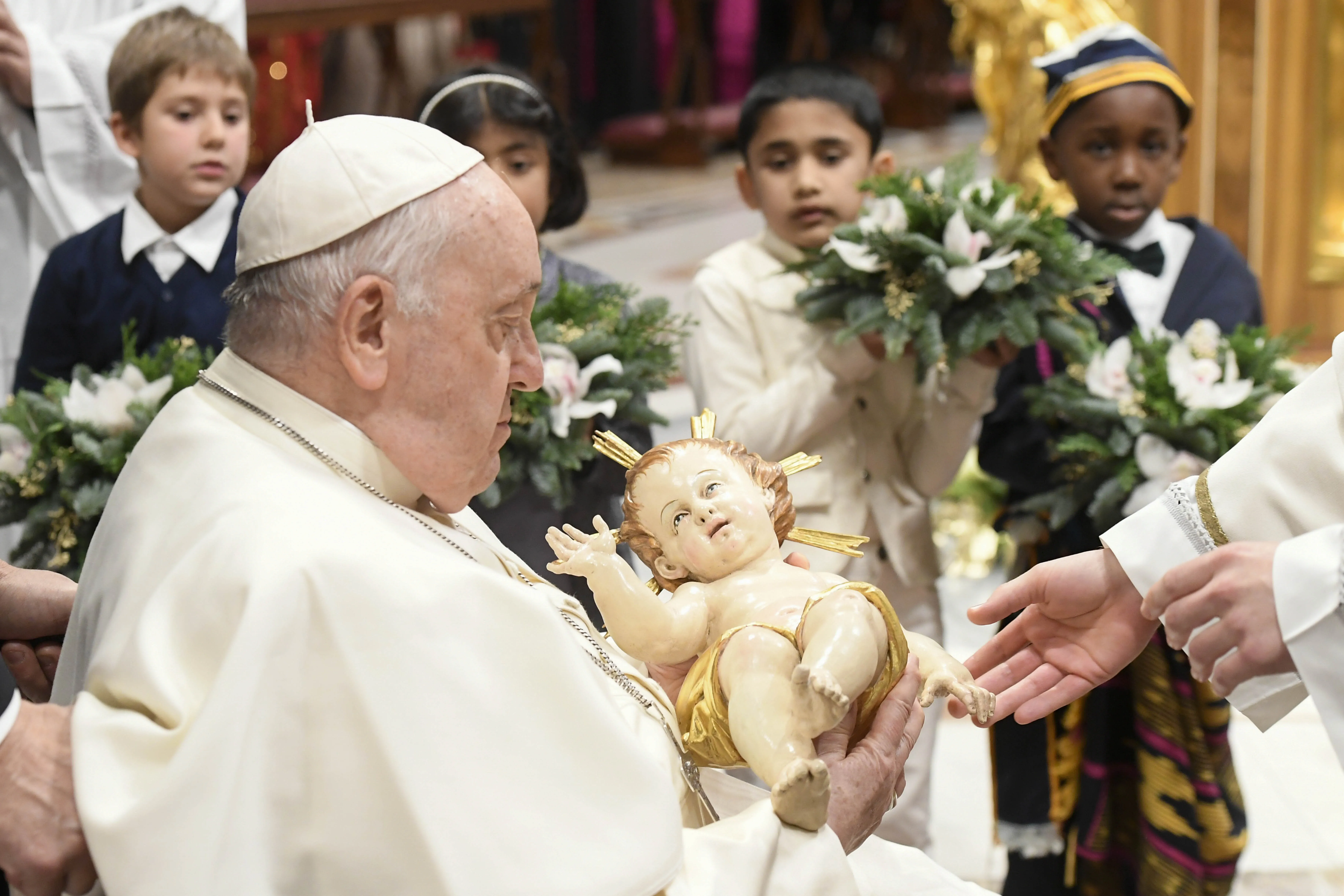 Pope Francis takes a figure of the Christ child in his arms at the end of the Vatican's Mass for the Nativity of the Lord on Dec. 24, 2023.?w=200&h=150