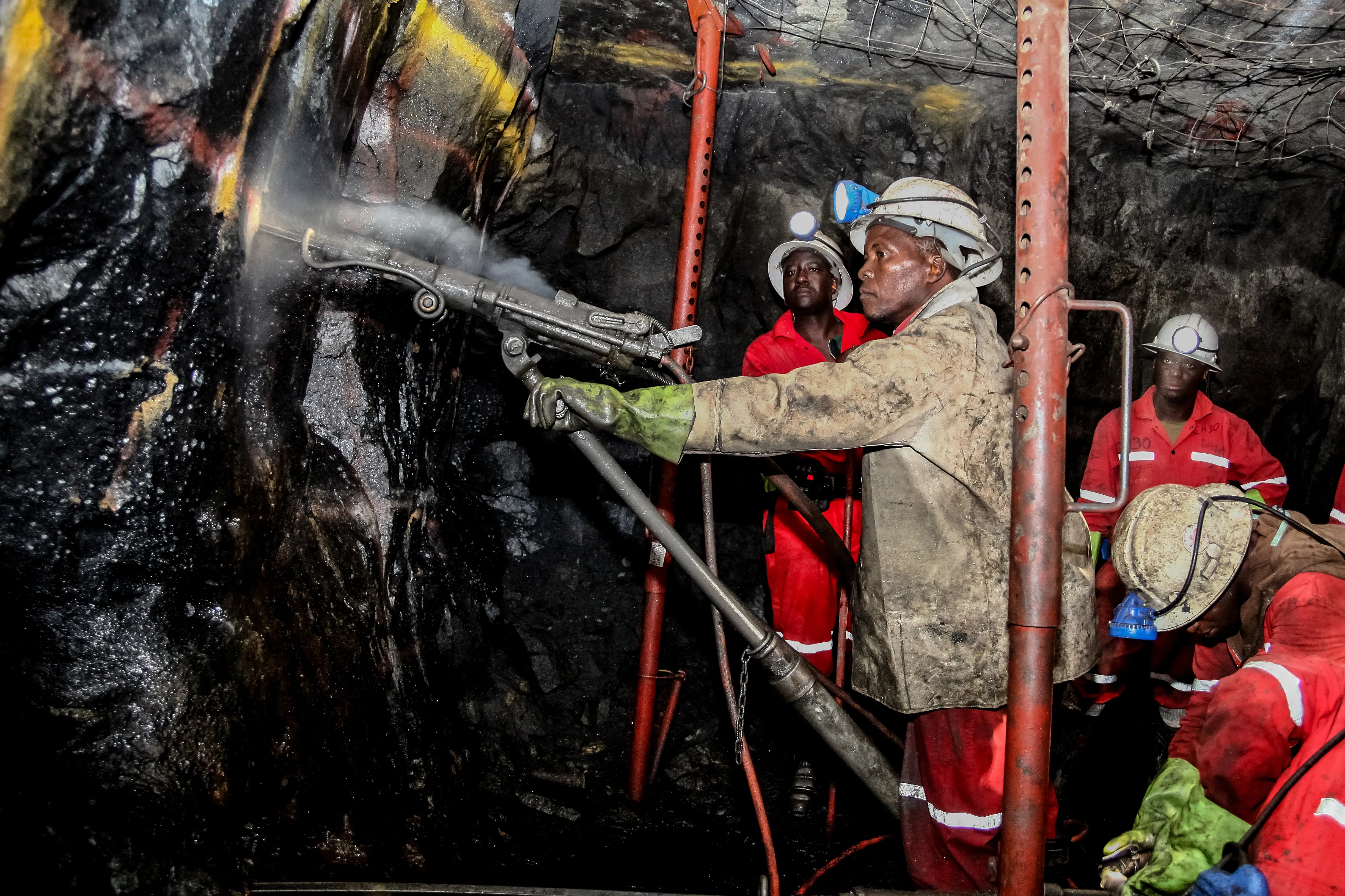 South African platinum and chrome miners drilling holes in rock for blasting.?w=200&h=150