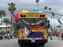 A school bus with rainbow-colored balloons, a Pride flag, and “love its love” signs drives in the Los Angeles Pride parade in Hollywood on June 11, 2023.