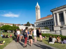 Students at the University of California, Berkeley, with the Campanile tower in the background.