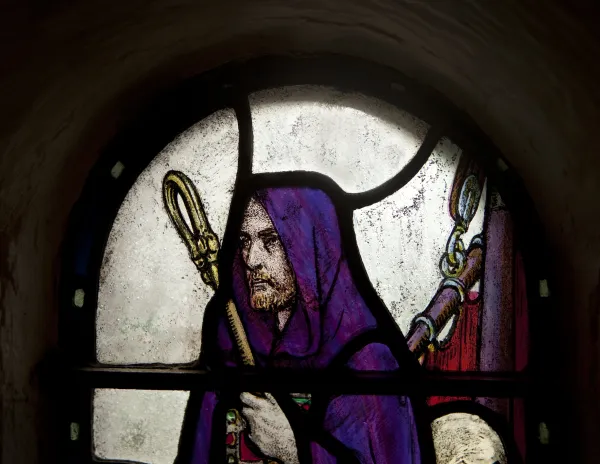 St. Columba with cloak and shepherd's crook in a stained-glass window in St. Margaret's Chapel in Edinburgh Castle. Shutterstock