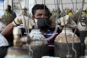 A worker refills medical oxygen cylinders for COVID-19 patients in New Delhi, India.