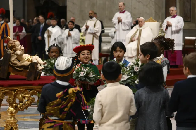 Children place flowers before a figure of the Christ child enthroned in front of the altar of St. Peter's Basilica.