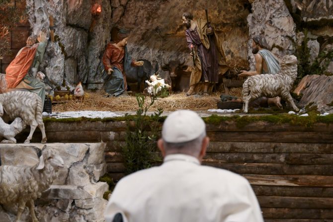 Pope Francis prays in front of the nativity scene in St. Peter's Basilica.