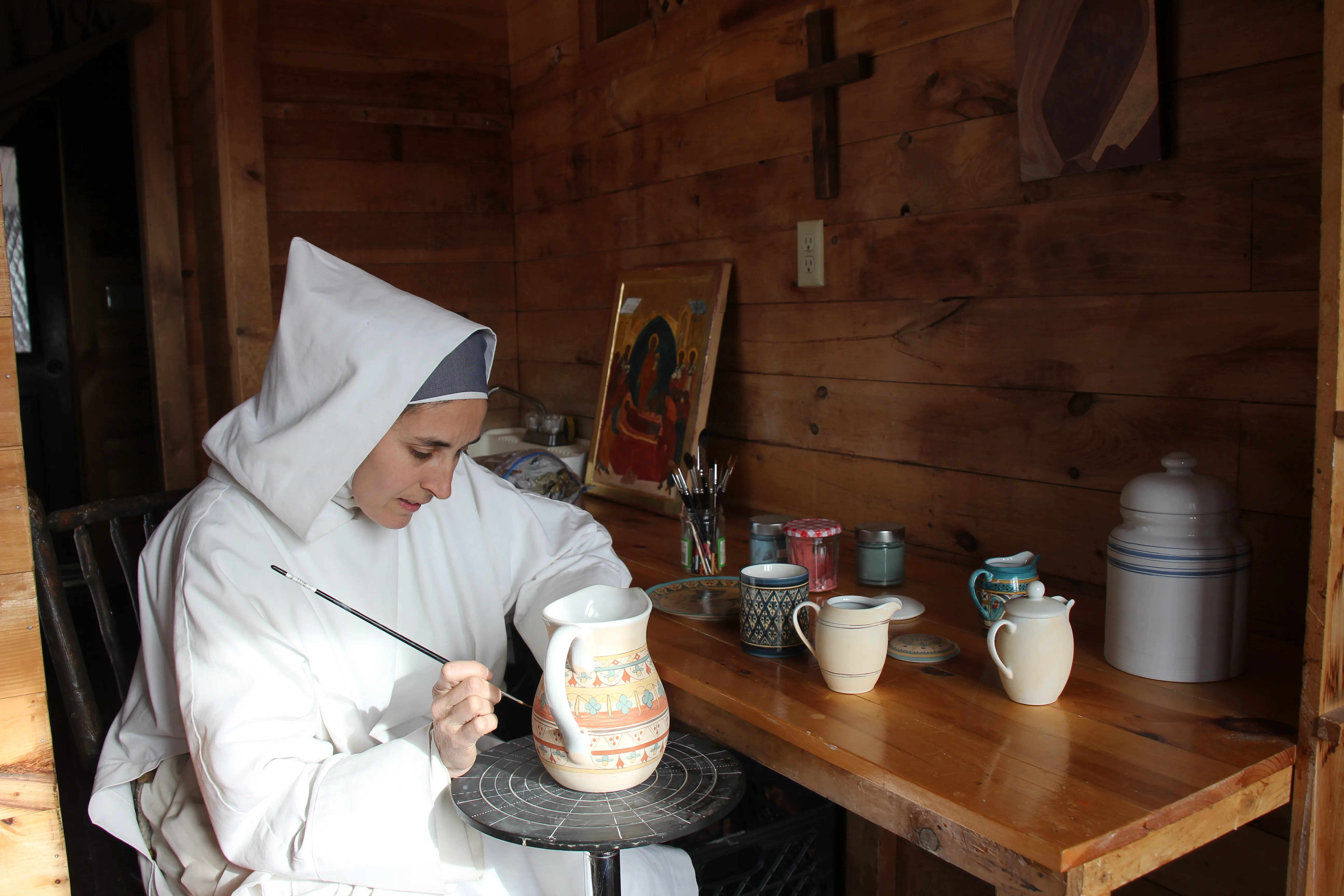 A religious sister from the Monastery of Bethlehem in Livingston Manor, New York, hand-paints a pitcher.?w=200&h=150