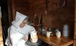 A religious sister from the Monastery of Bethlehem in Livingston Manor, New York, hand-paints a pitcher.