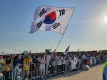 Pilgrims from South Korea wave a flag at the closing Mass of World Youth Day Lisbon with Pope Francis on Aug. 6, 2023.