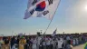 Pilgrims from South Korea wave a flag at the closing Mass of World Youth Day Lisbon with Pope Francis on Aug. 6, 2023.