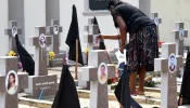 A woman was seen paying tribute to victims of the 2019 Easter Sunday terror attacks at a cemetery in Negombo, Sri Lanka.