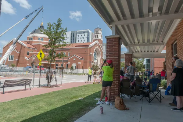 Members of the St. Mary's Catholic Center community watch as the Our Lady of Victory statue is installed at the top of the new church, which will be dedicated July 29, 2023. Credit: Photo courtesy of St. Mary’s Catholic Center