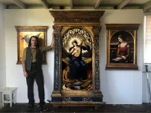 David Troncoso stands in his art studio with an altarpiece he recently completed.