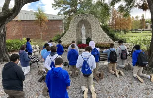 A group of students from Jesuit High School, an all-boys school in Tampa, Florida, praying in front of a statue of Our Lady. Jimmy Mitchell