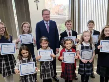 Students who are all winners of the St. Joseph art contest stand alongside Thomas Carroll, superintendent of schools for the Archdiocese of Boston.