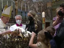 Pope Francis baptizes a child in the Sistine Chapel on Jan. 9, 2021.