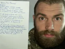Major Serhiy Volyna, who has been leading the 36th marine brigade in the battle for the Ukrainian port city of Mariupol, pictured holding his letter to Pope Francis.