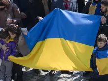 People raise the Ukrainian flag at Pope Francis' Angelus address at the Vatican, March 6, 2022.
