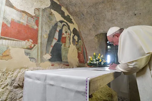 Pope Francis signs his apostolic letter Admirabile signum at the place where St. Francis created the first Nativity scene outside of Greccio, Italy, on Dec. 1, 2019. Credit: Vatican Media