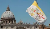 The Vatican flag and the dome of St. Peter's Basilica.