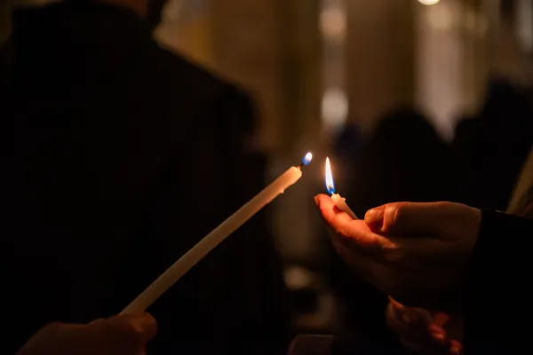 On Friday evening, Oct. 27, the Franciscans gathered for a moment of prayer in the Church of St. Savior, in Jerusalem. Before the final blessing, a candle was lit at the paschal candle, and the light was passed from person to person. Credit: Marinella Bandini