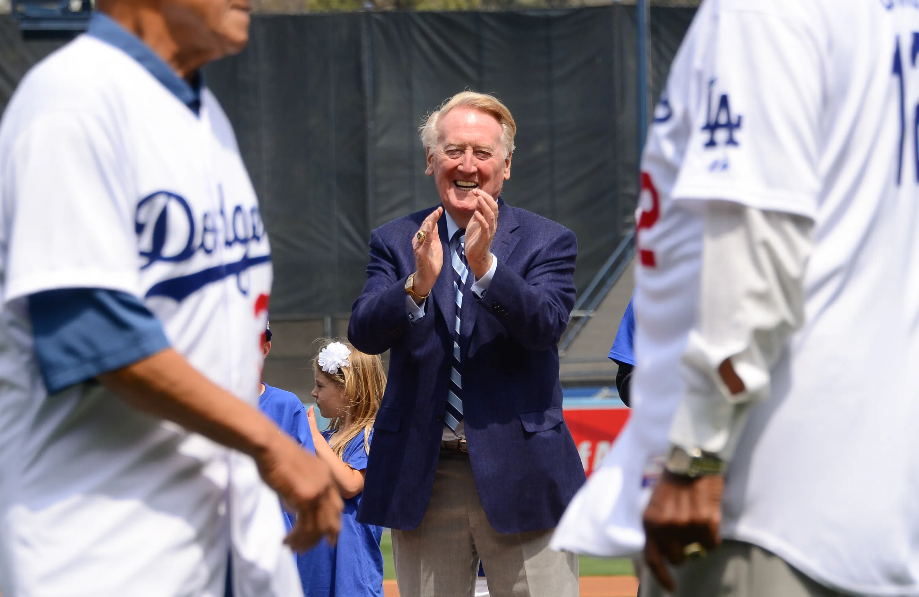 Longtime baseball broadcaster Vin Scully applauds Los Angeles Dodger hall of famers during opening day pre-game ceremonies on April 4, 2014, in Los Angeles, California.?w=200&h=150