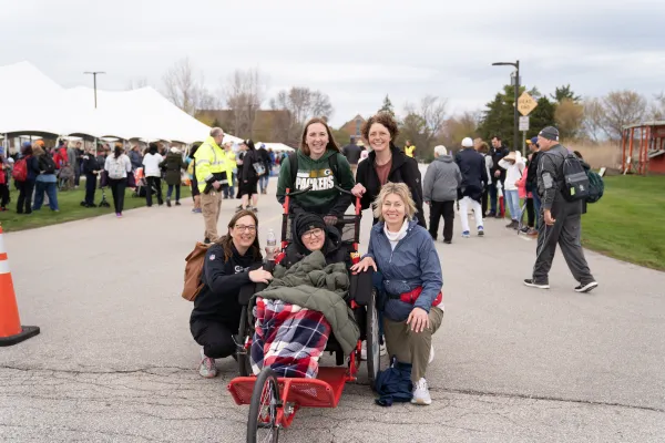 Karmen Lemke (right, kneeling), along with a group of friends and family, assist Doris Lamers on what would be her final Walk to Mary pilgrimage experience. Credit: Karmen Lemke