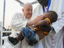 Pope Francis greets a young boy a Mass in Juba, South Sudan on Feb. 5, 2023.