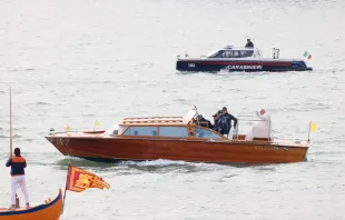Pope Francis waves while traveling by boat in Venice, Italy, for a meeting with young people at the Basilica della Madonna della Salute on April 28, 2024. Earlier in the day he met with inmates at a women's prison. Credit: Daniel Ibañez/CNA